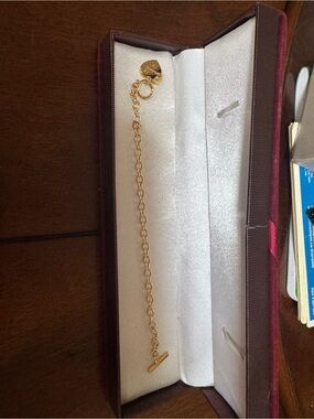 Coach heart gold bracelet features a polished gold-tone heart charm toggle